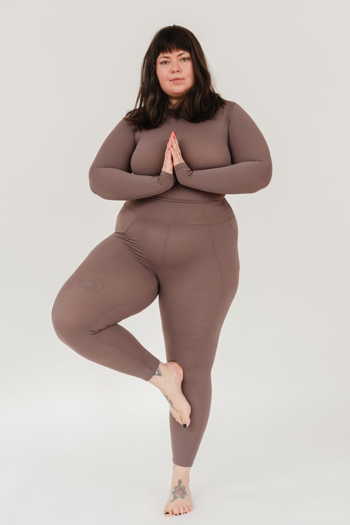 Femme surpoids équilibrée en position de yoga